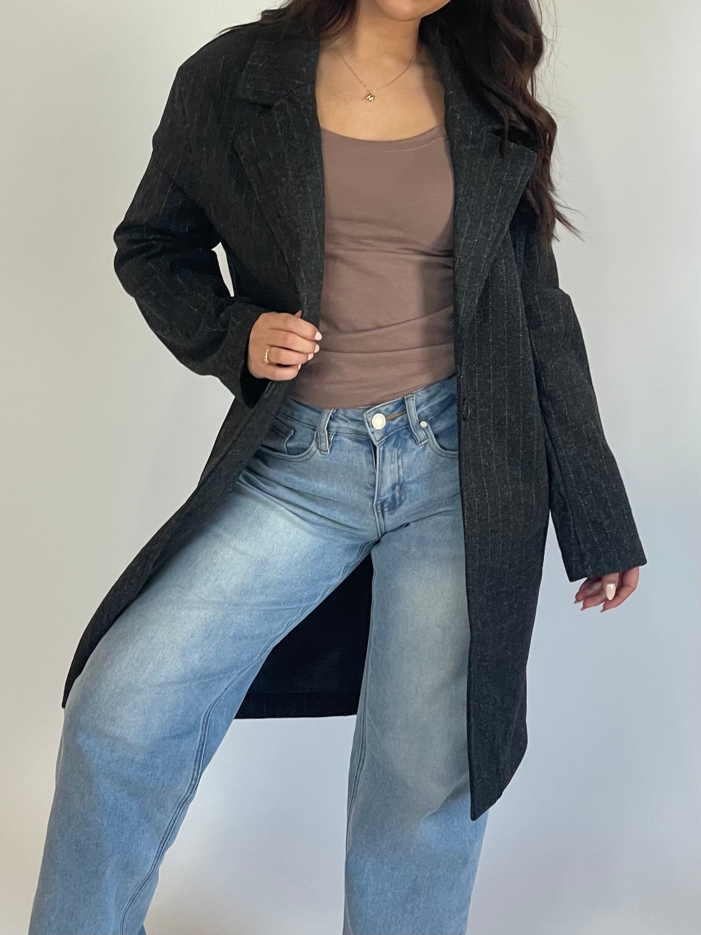 This long pinstripe coat is designed for both fashion and function. It is meant to be worn open. Stay stylish and cozy with this versatile piece! Black with thin, white pinstripes.