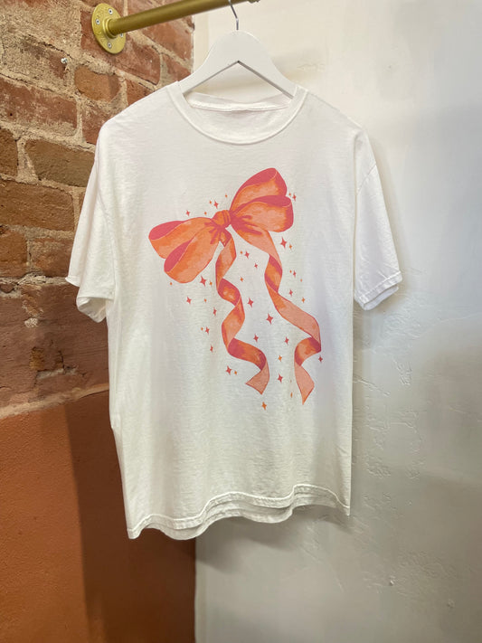 Pink bow graphic on white oversized t-shirt. Only on the front. Relax fit. 